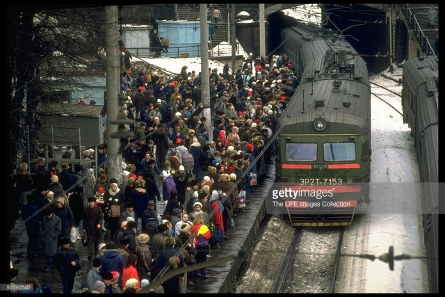 Rail passengers carrying shopping & overnight-sized bags packing platform, waiting to bd. train, at Belorussian train station, Moscow (February 19, 1992).jpg