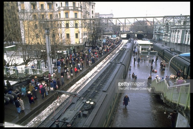 Rail passengers carrying shopping & overnight-sized bags packing platform, waiting to bd. train, at Belorussian train station in Moscow (February 19, 1992).jpg